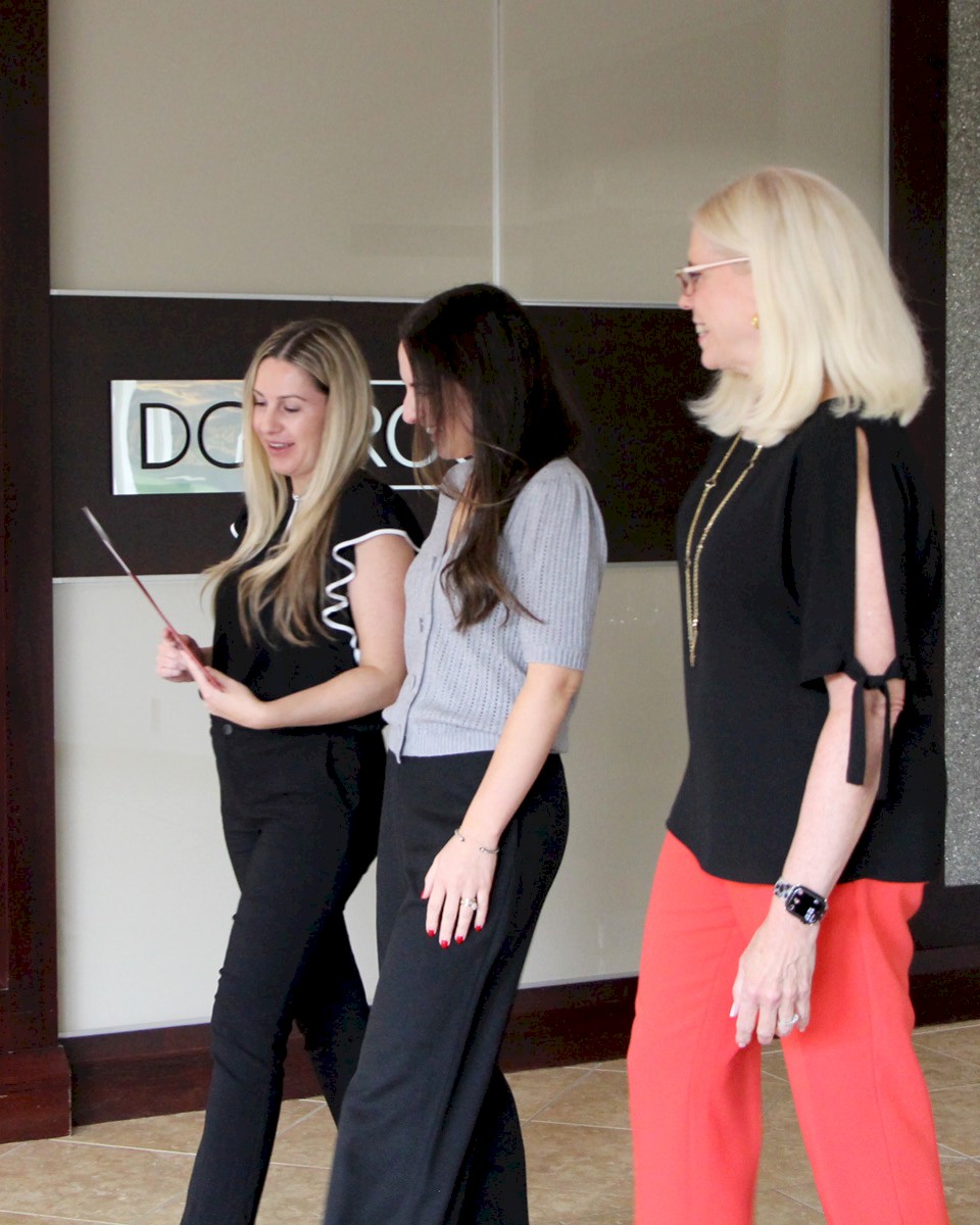 DG Group staff members reviewing document, smiling.