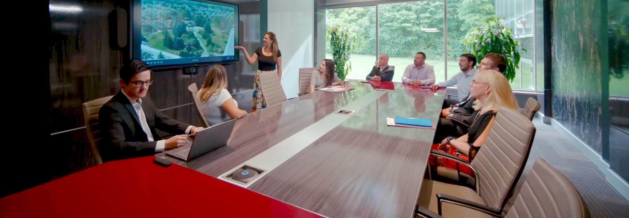 DG Group team meeting in a boardroom, reviewing drone footage.